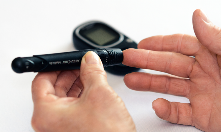 Diabetes patient pricks finger to test blood sugar