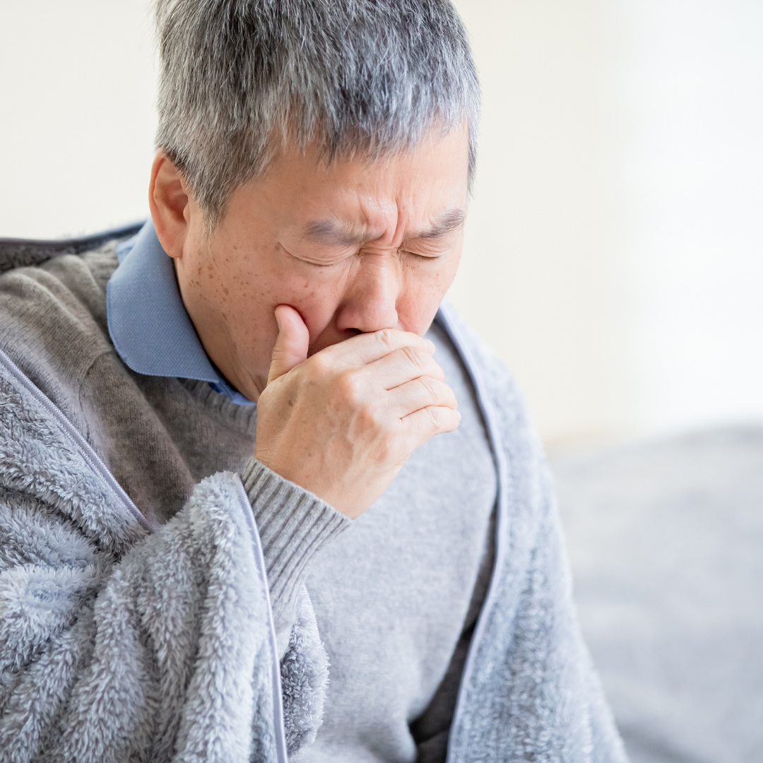 asian man coughing in hand