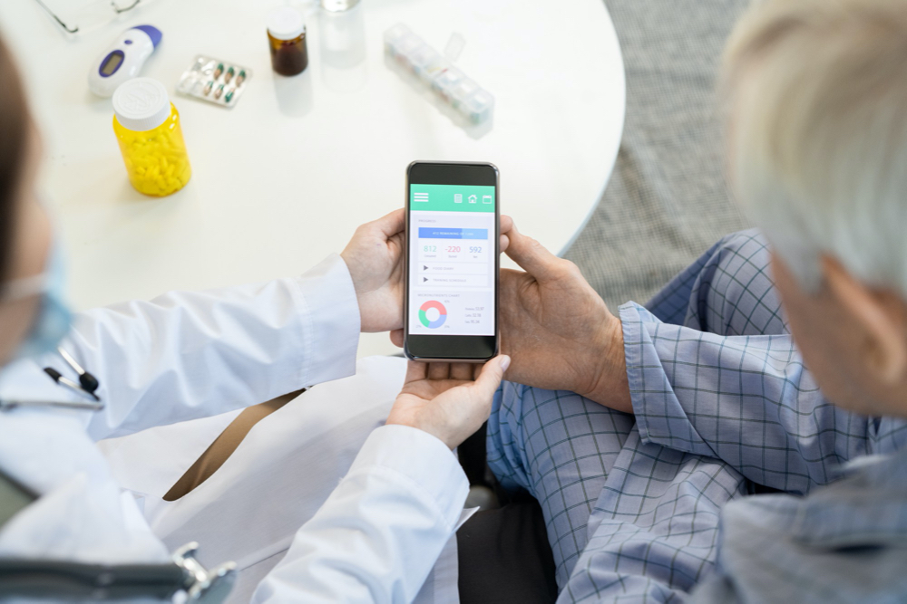 Photo hands of female general practitioner in whitecoat using smartphone to look through results of individual health