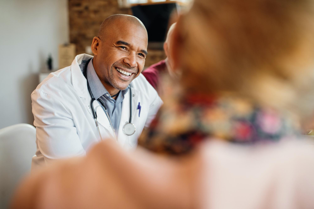 photo happy african american doctor in a home visit