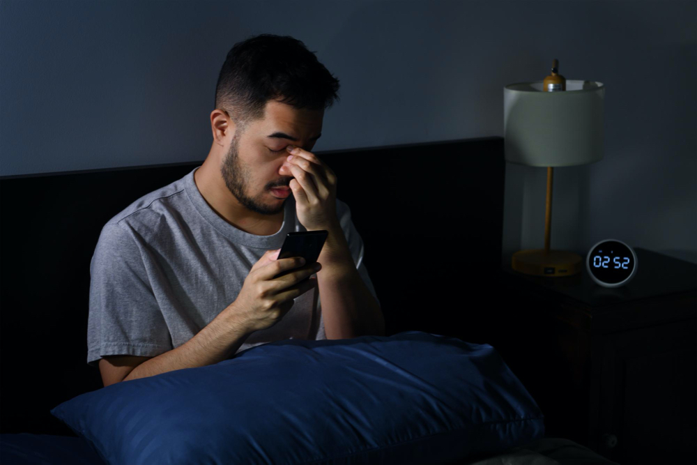 man with clogged nose at night in bed 