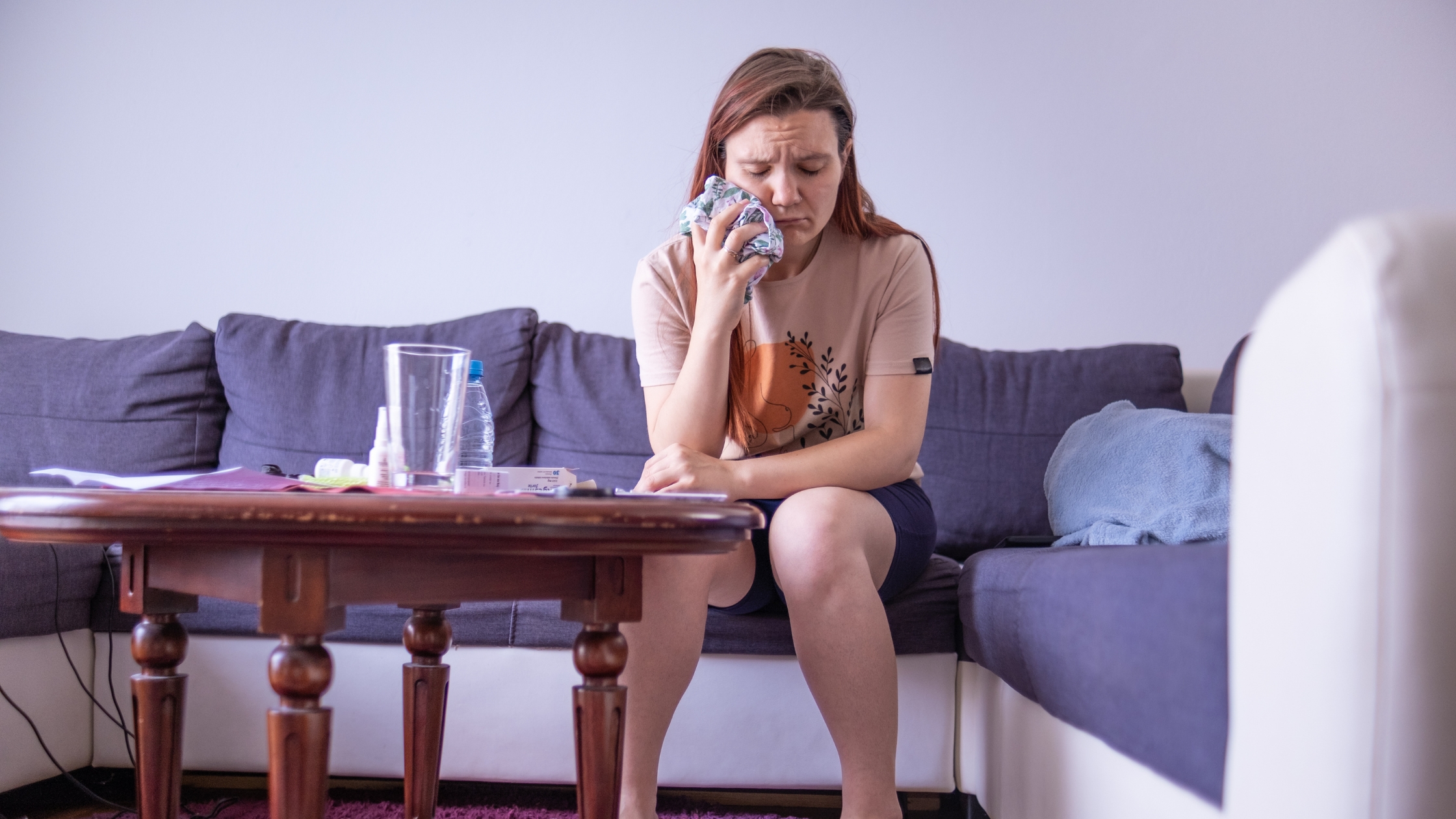 A woman holding cold compress to her face to remedy her gum swelling