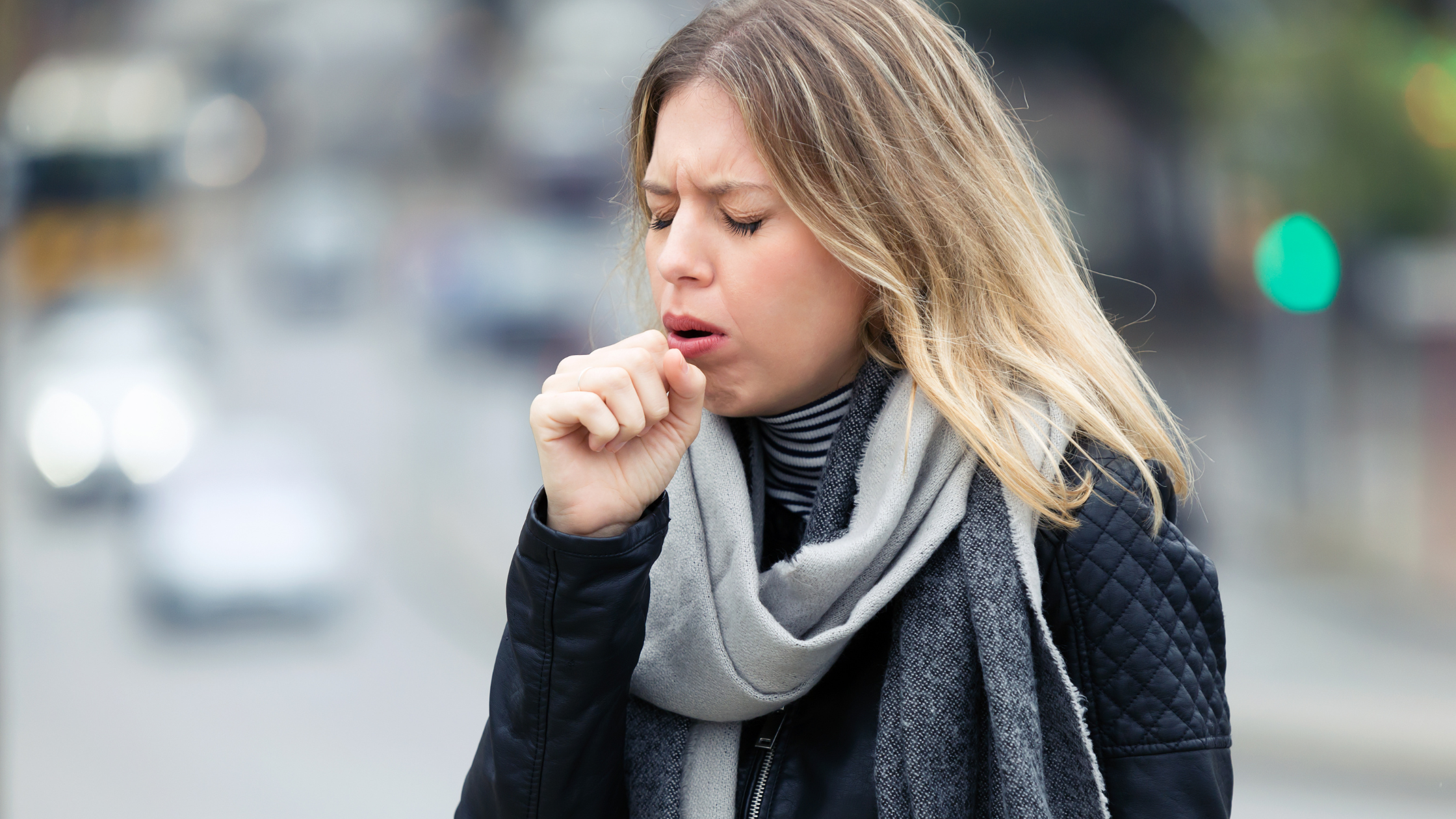 A woman coughing due to walking pneumonia